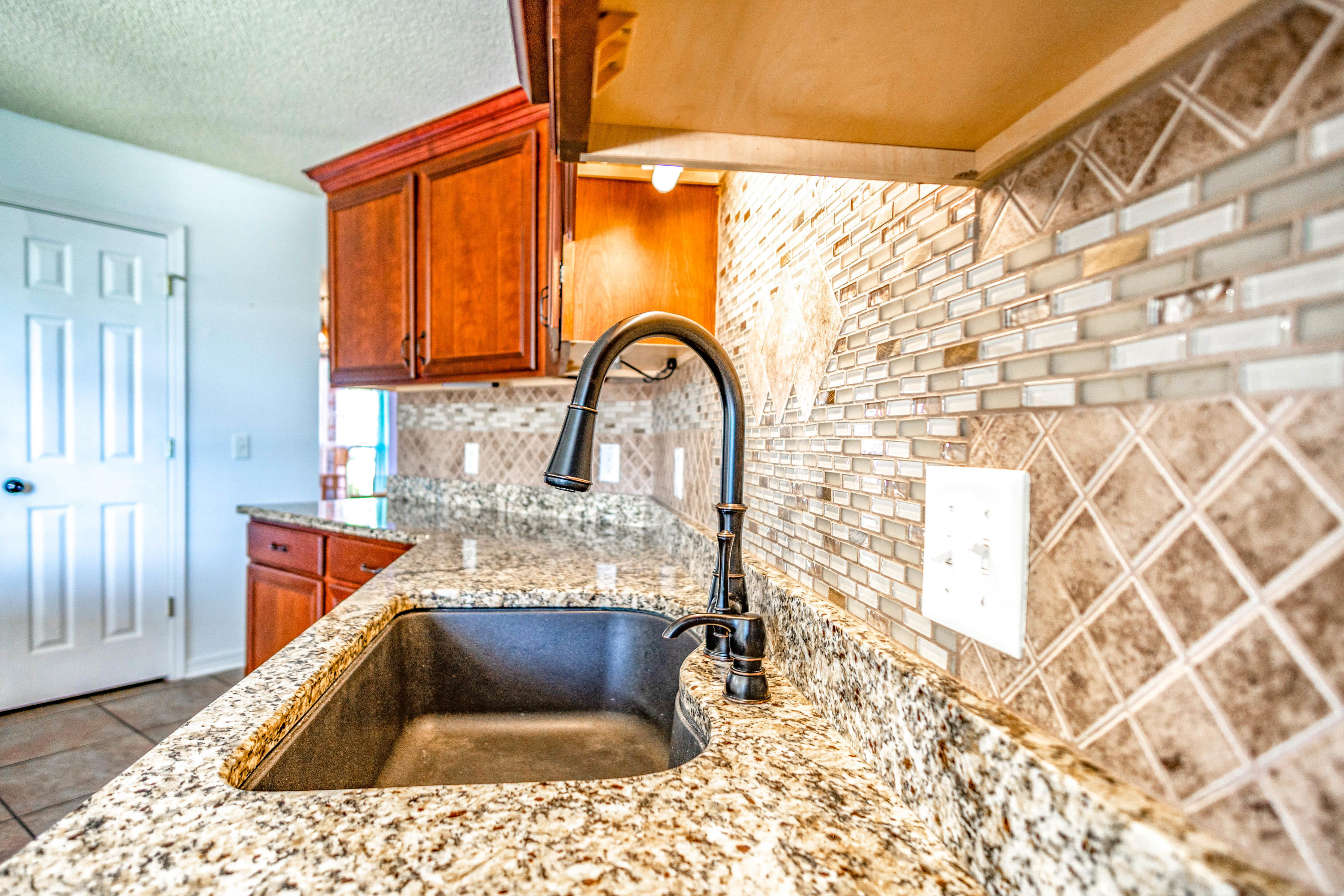7105 Snug Waters Road Navarre, FL 32566 - Photo 8 of 42 a kitchen with a sink a stove and a microwave oven