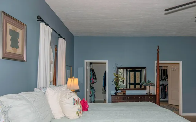 a bedroom with a bed and large windows