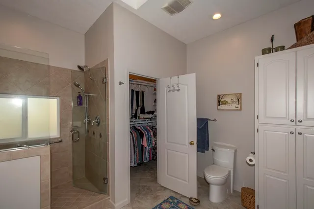 a bathroom with a granite countertop toilet a sink and shower