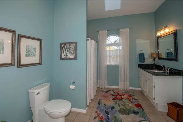 a spacious bathroom with a toilet sink and mirror