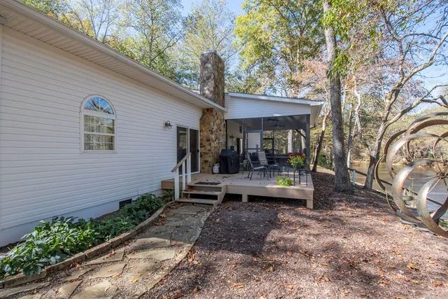 a view of a patio with table and chairs potted plants and large tree