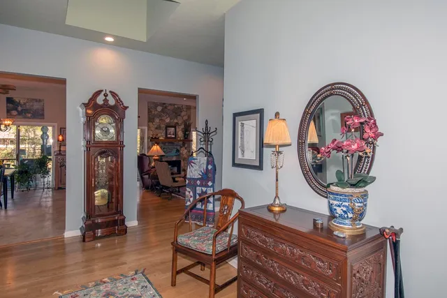a living room with furniture a piano and wooden floor
