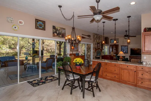 a dining room filled with furniture and floor to ceiling windows