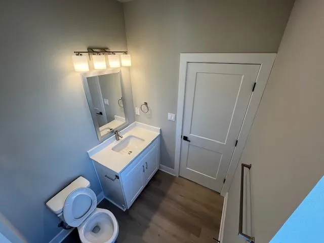 a bathroom with a toilet mirror vanity and a sink