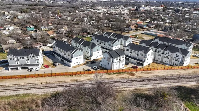 an aerial view of residential houses with yard