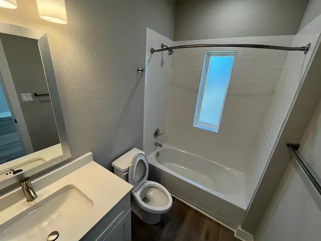 an empty room with wooden floor and fan