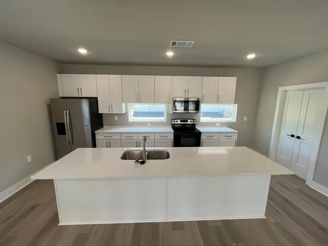 a kitchen with kitchen island a refrigerator sink and stove