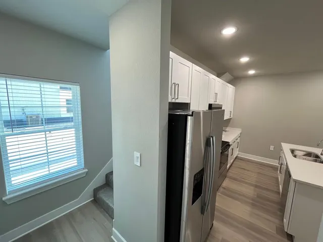 a view of a kitchen with wooden floor and a window