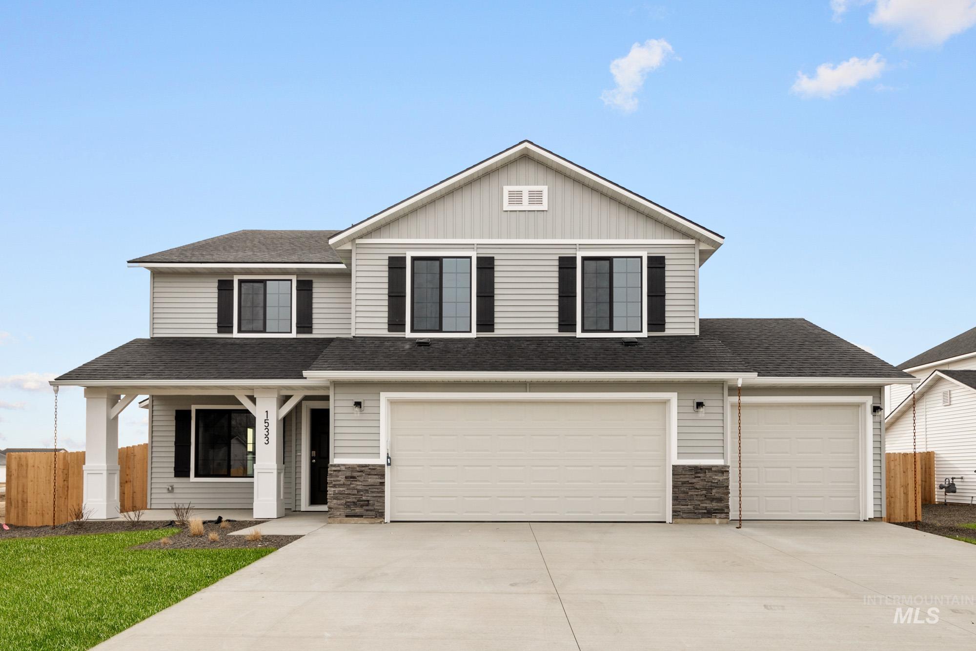 View of front facade with concrete driveway, a shingled roof, a garage, and board and batten siding