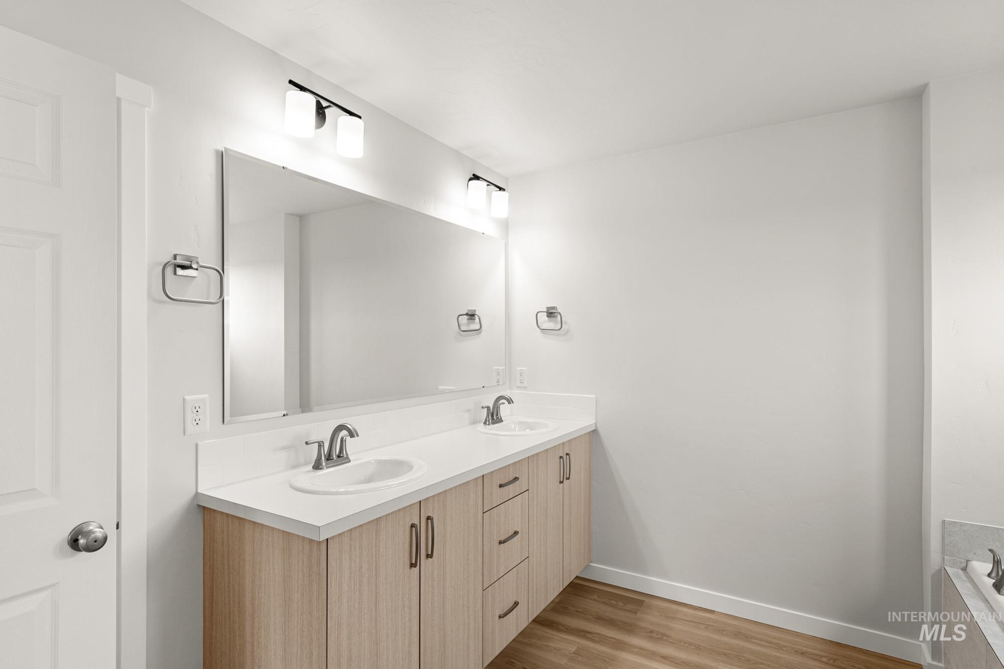 1533 Long Pond Street Middleton, ID 83644 - Photo 18 of 21 Full bath featuring double vanity, light wood-type flooring, and tiled tub