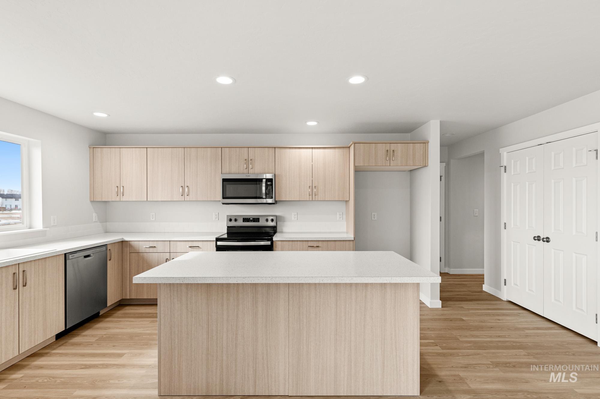 1533 Long Pond Street Middleton, ID 83644 - Photo 3 of 21 Kitchen featuring light wood finish cabinetry, light countertops, stainless steel appliances, light wood-style floors, and recessed lighting