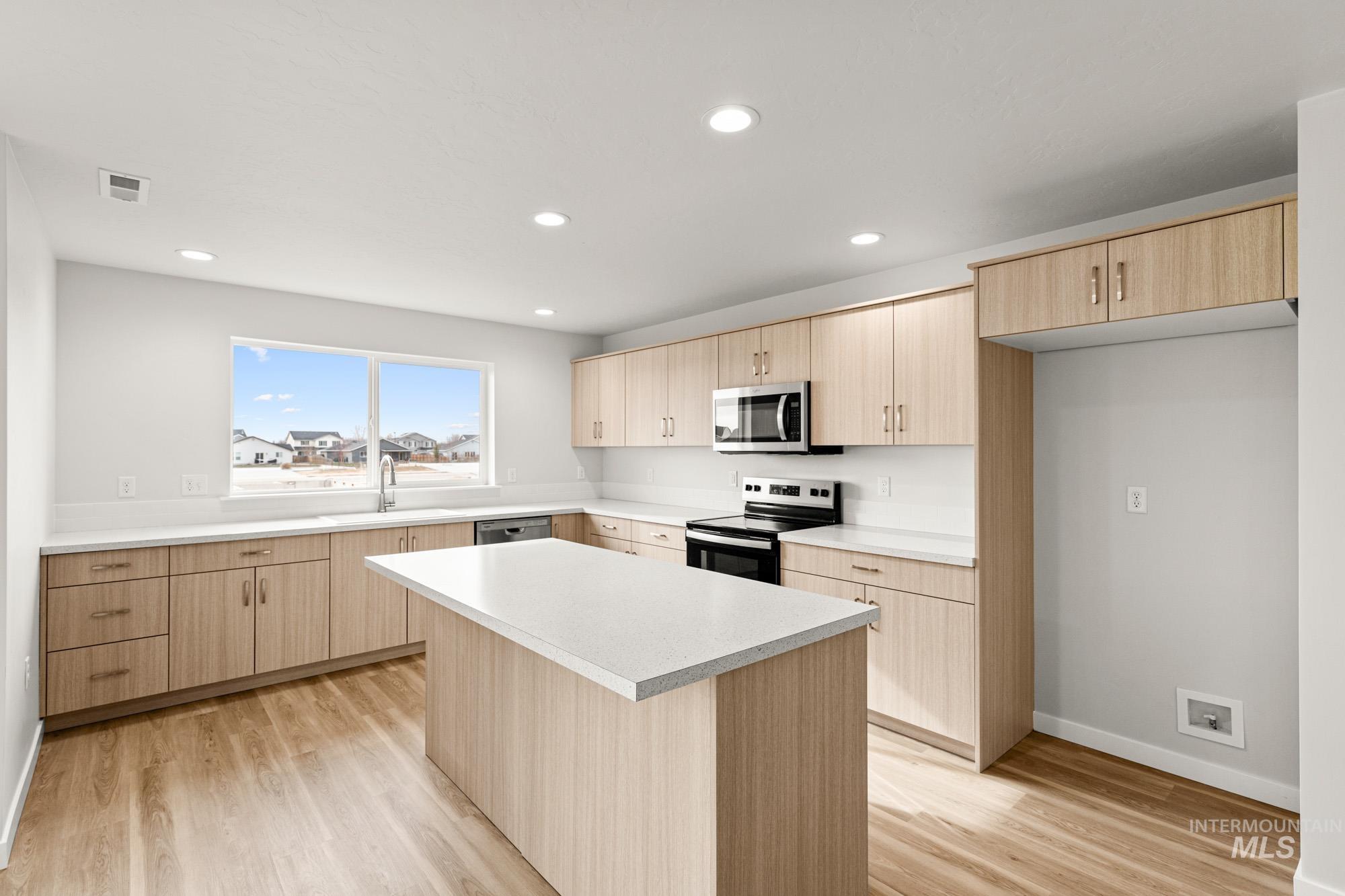 1533 Long Pond Street Middleton, ID 83644 - Photo 4 of 21 Kitchen with light wood finish cabinets, stainless steel appliances, light wood-style floors, and recessed lighting