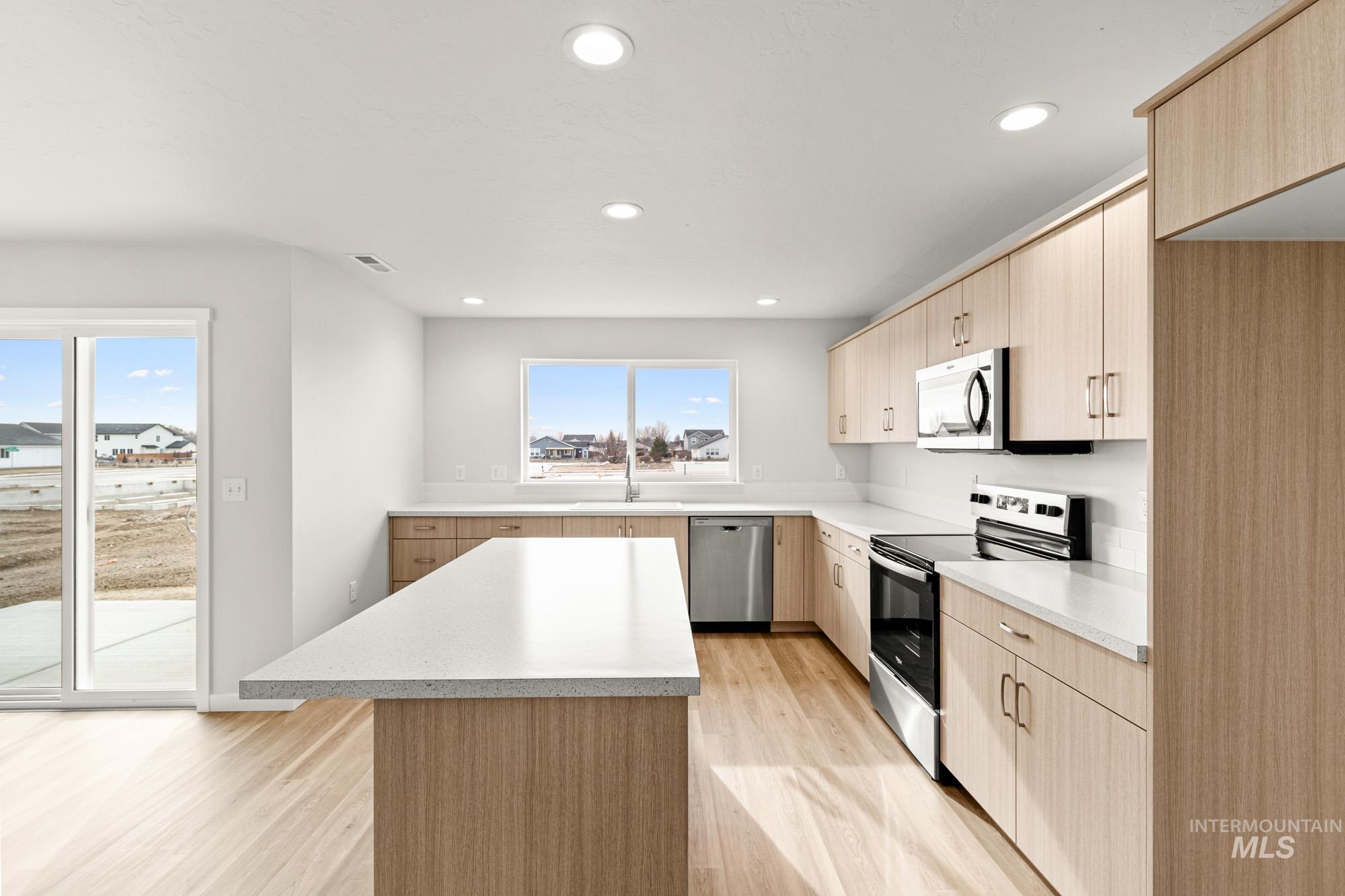 1533 Long Pond Street Middleton, ID 83644 - Photo 5 of 21 Kitchen with light wood finish cabinetry, stainless steel appliances, light wood-type flooring, a center island, and recessed lighting