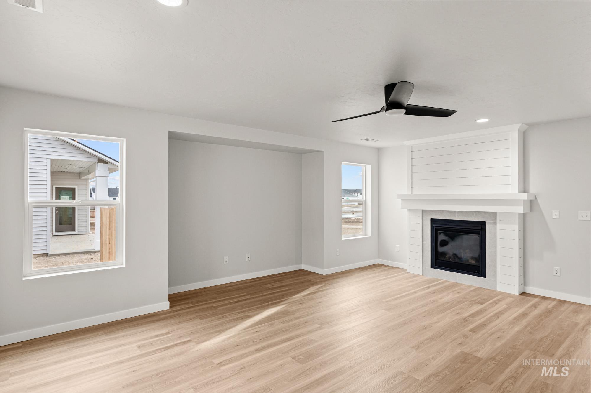 1533 Long Pond Street Middleton, ID 83644 - Photo 8 of 21 Unfurnished living room with a ceiling fan, light wood-type flooring, recessed lighting, and a fireplace