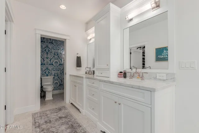 a bathroom with a double vanity sink mirror and toilet
