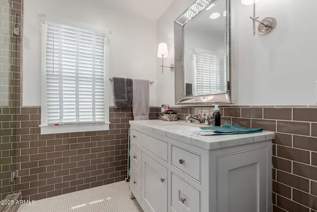 a bathroom with a granite countertop sink and a mirror