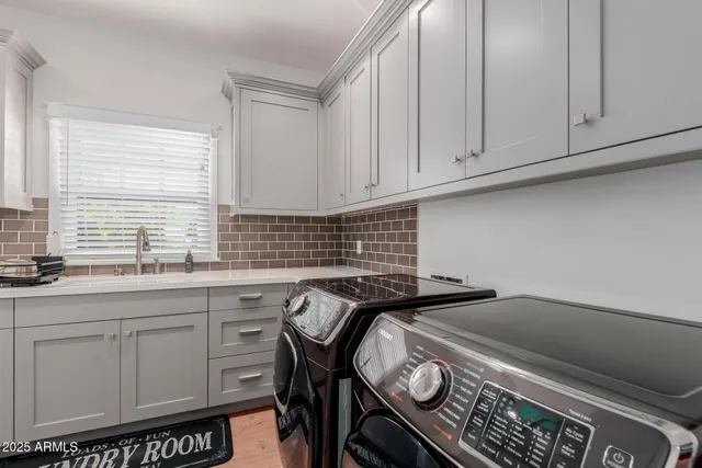 a kitchen with granite countertop a stove a sink and white cabinets
