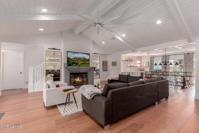 a living room with furniture a fireplace and a chandelier