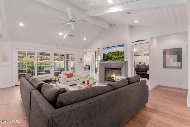 a living room with furniture a fireplace and a chandelier