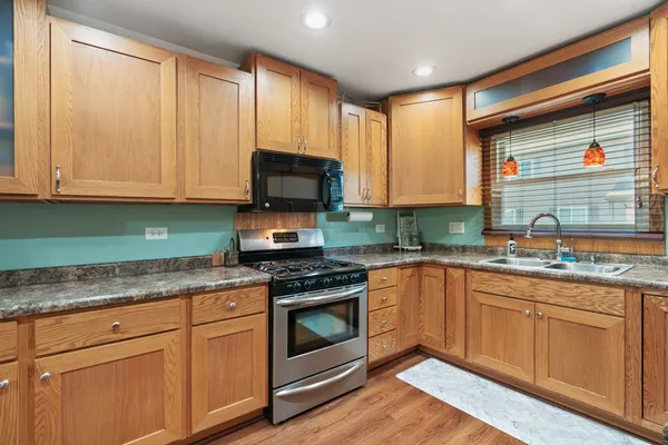 a kitchen with granite countertop wooden cabinets and a wooden floor