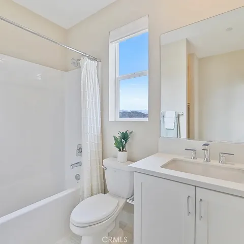 a bathroom with a sink a toilet a mirror and shower