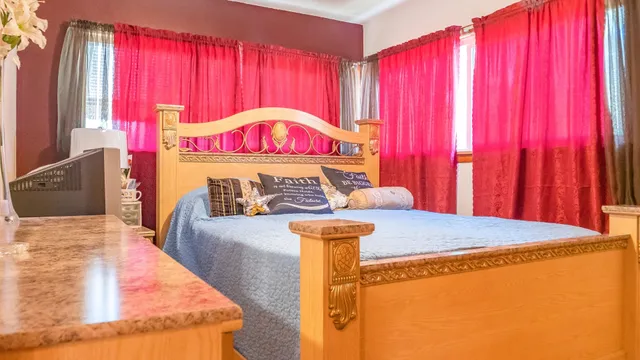 a bed sitting in a bedroom next to a window