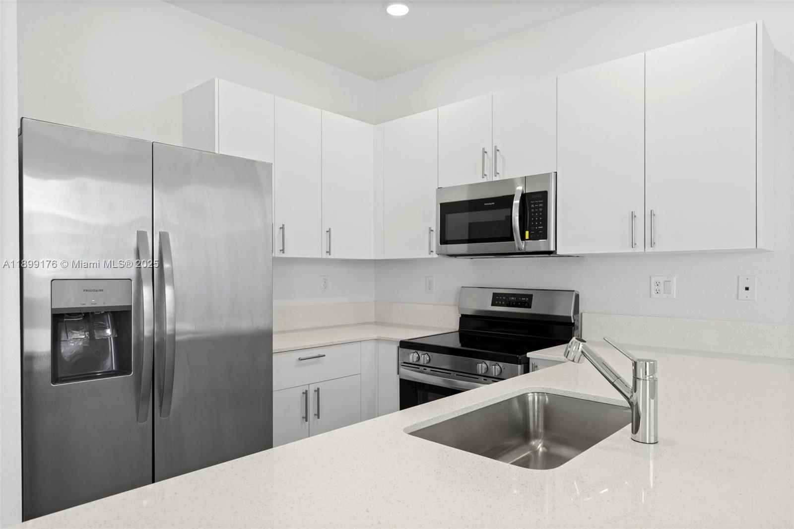 715 Southeast 15th Street Homestead, FL 33034 - Photo 14 of 33 a kitchen with white cabinets and stainless steel appliances