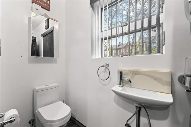a bathroom with a toilet a sink and mirror