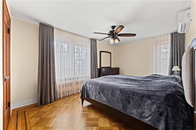 a bedroom with a bed dresser and a large window
