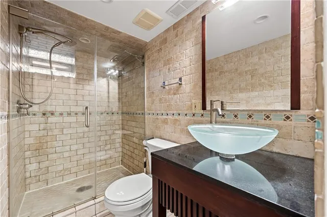 a bathroom with a sink a toilet and shower