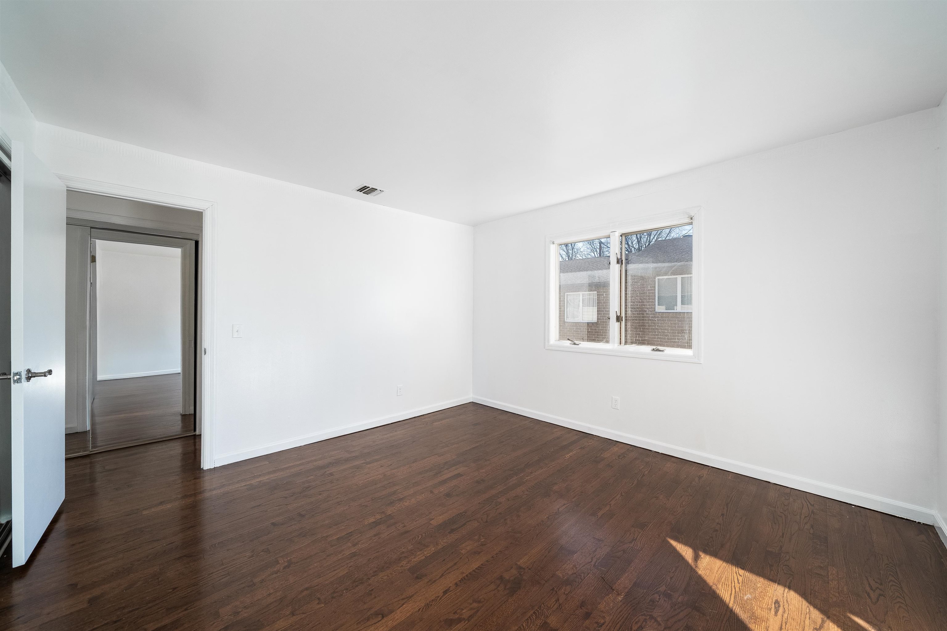 156 Main Street East Rutherford, NJ 07073 - Photo 12 of 19 a view of an empty room with wooden floor and a window