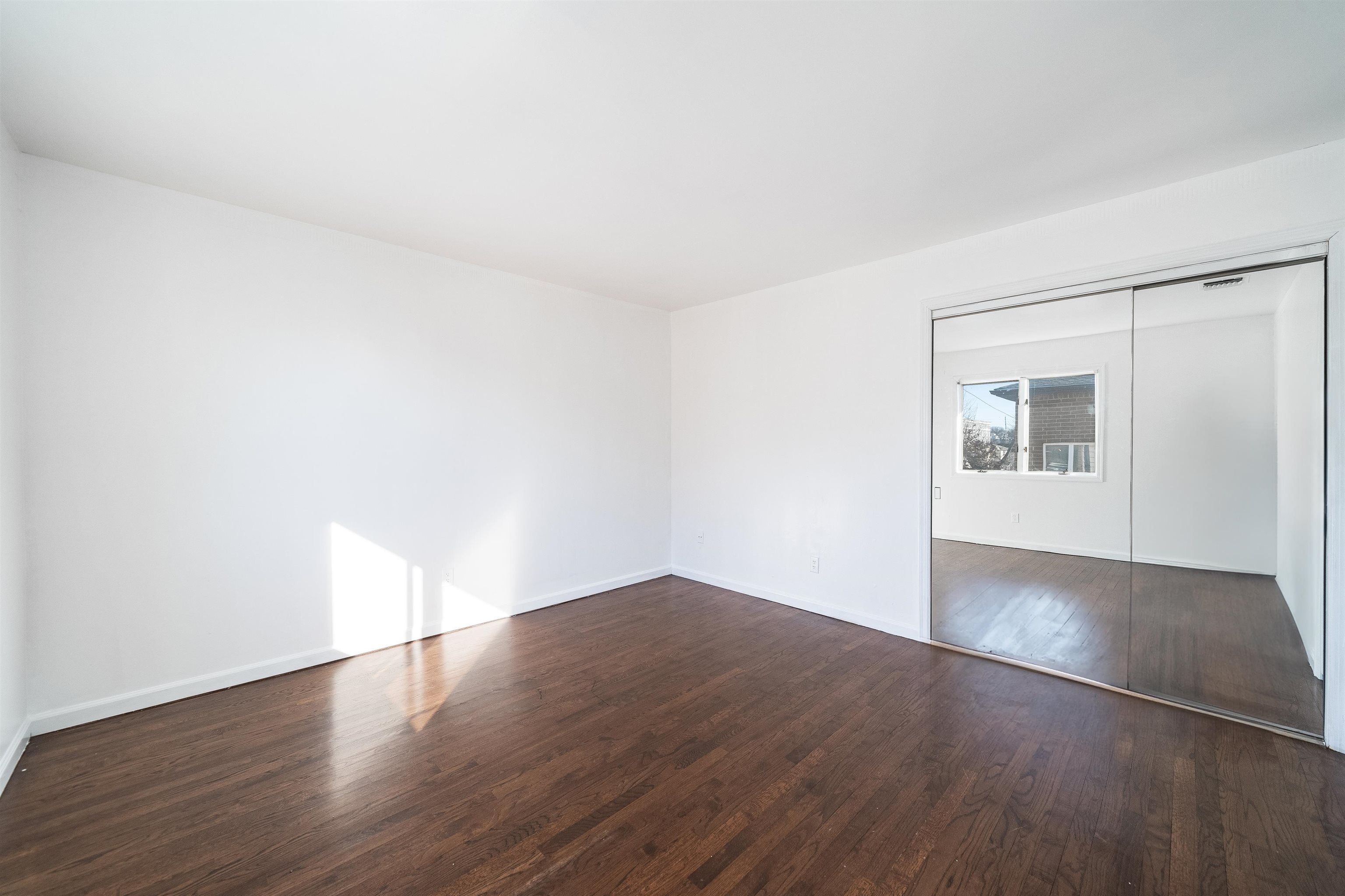 156 Main Street East Rutherford, NJ 07073 - Photo 14 of 19 an empty room with wooden floor and windows