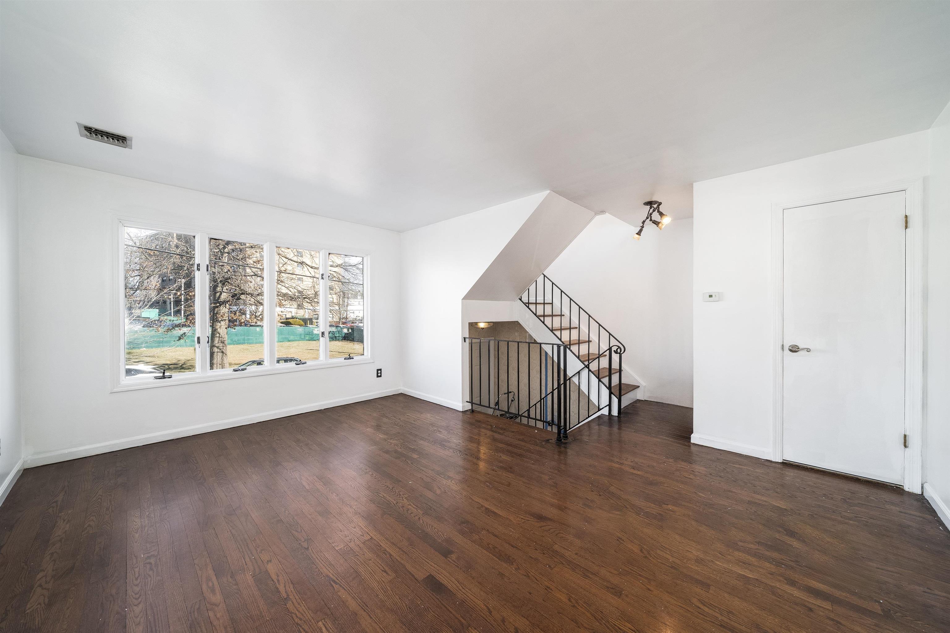 156 Main Street East Rutherford, NJ 07073 - Photo 3 of 19 a view of a room with wooden floor staircase and windows
