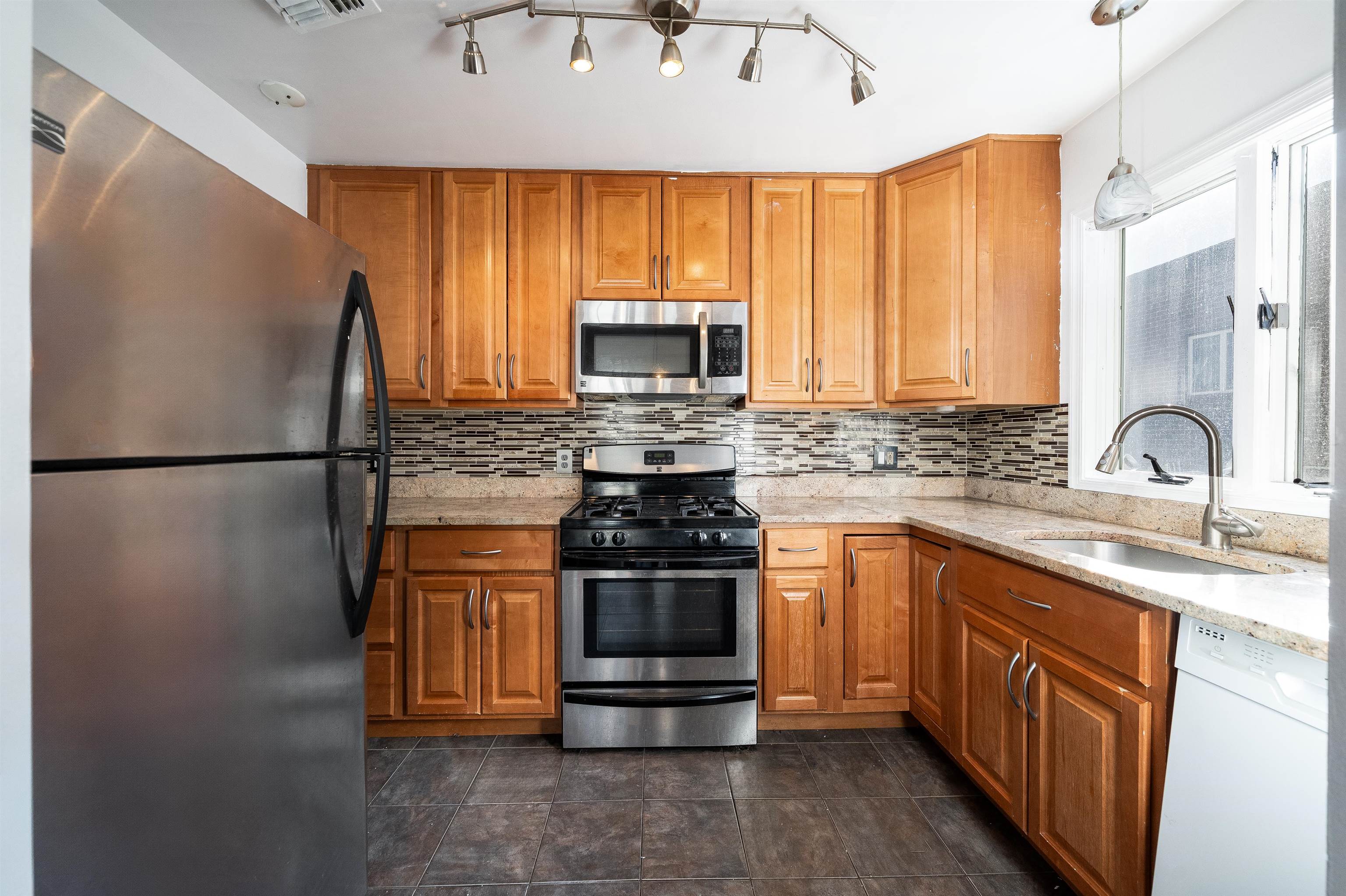 156 Main Street East Rutherford, NJ 07073 - Photo 8 of 19 a kitchen with stainless steel appliances granite countertop a stove a sink and a microwave