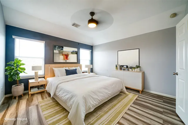 a bedroom with a bed and a flat tv screen on dresser