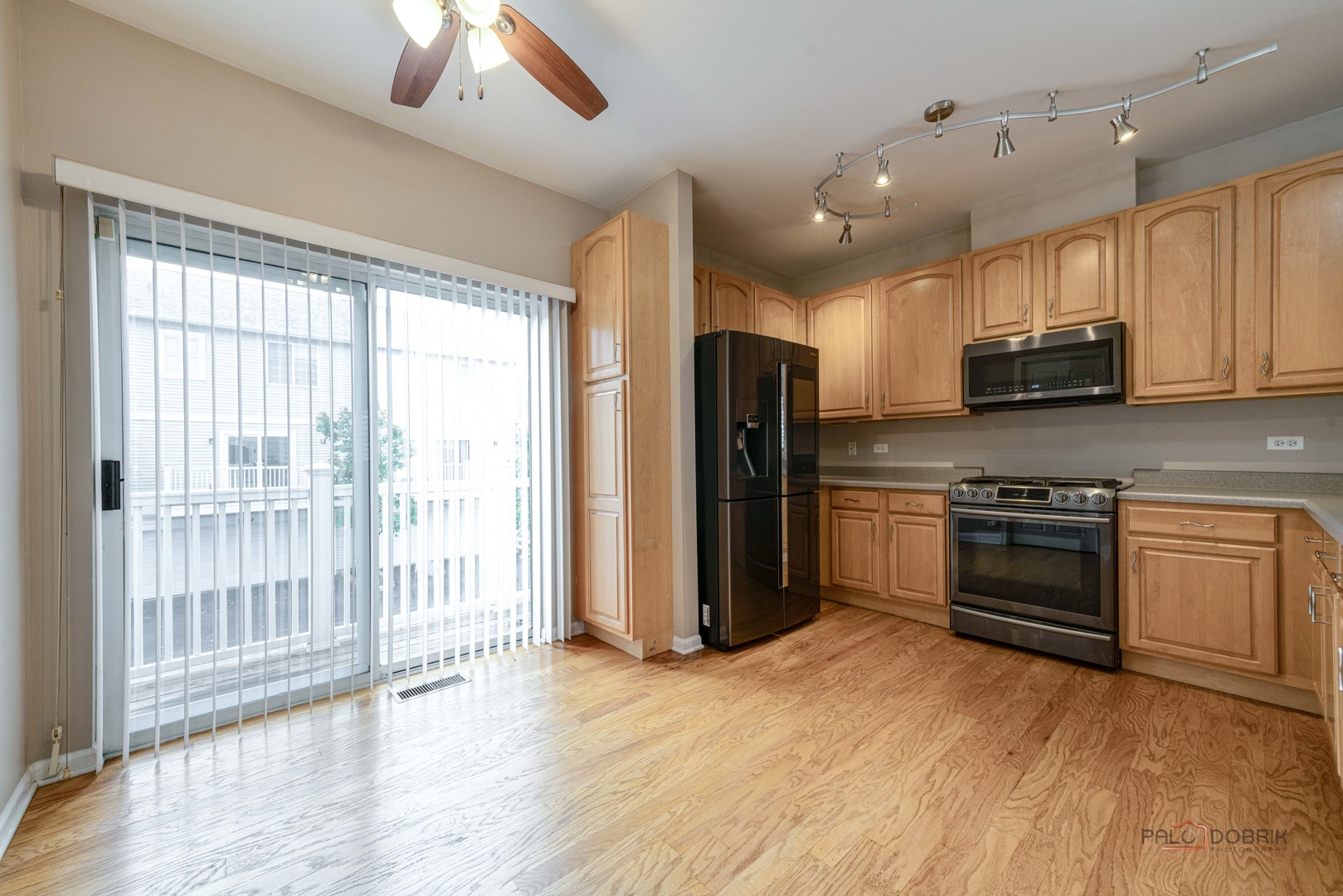 1719 Sienna Court Wheeling, IL 60090 - Photo 13 of 34 a kitchen with stainless steel appliances granite countertop a stove a refrigerator and a sink with wooden floor