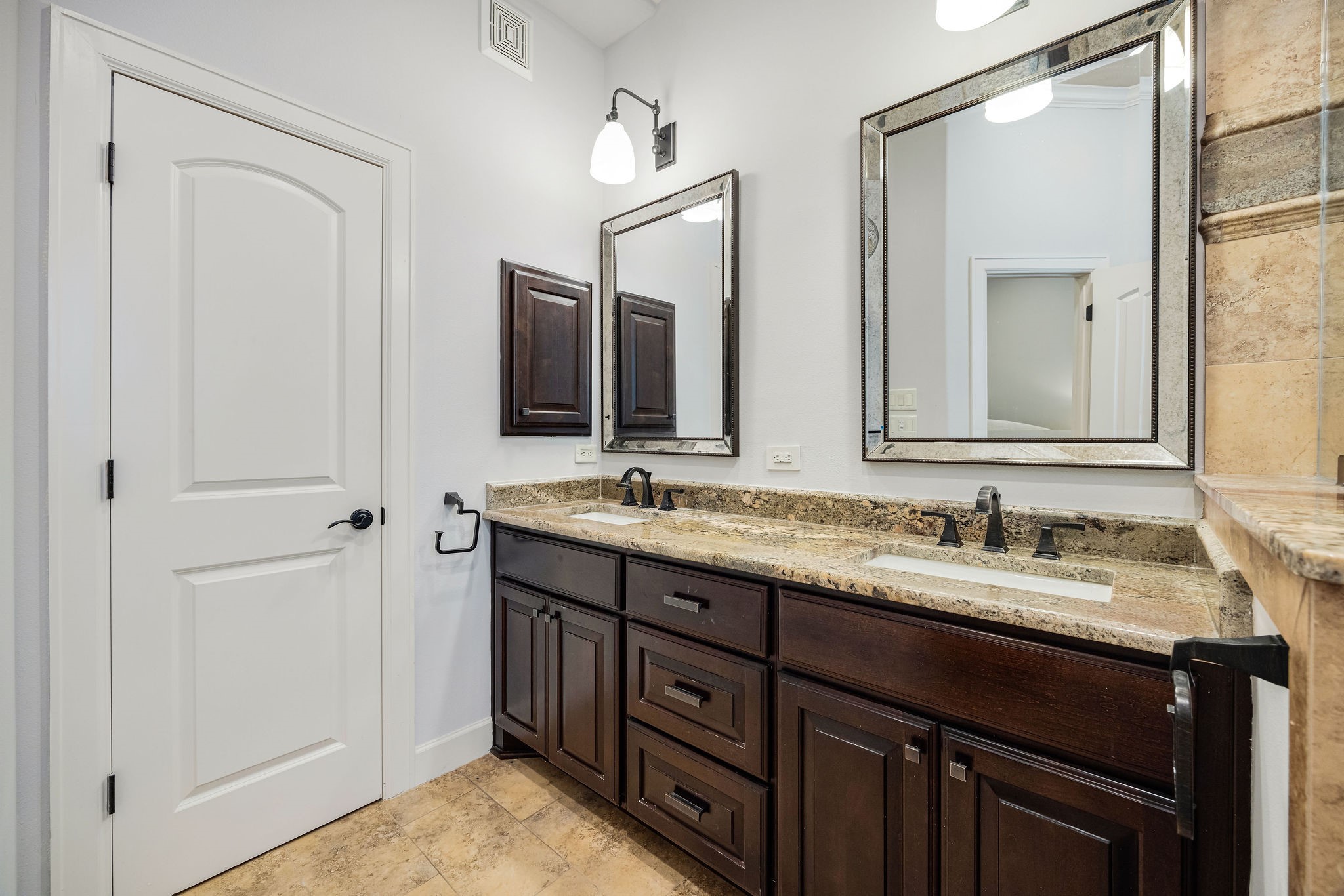 2415 Commonwealth Street Houston, TX 77006 - Photo 18 of 26 Dual vanities with granite countertops, abundant cabinetry, and generous storage make the primary bath as functional as it is elegant.