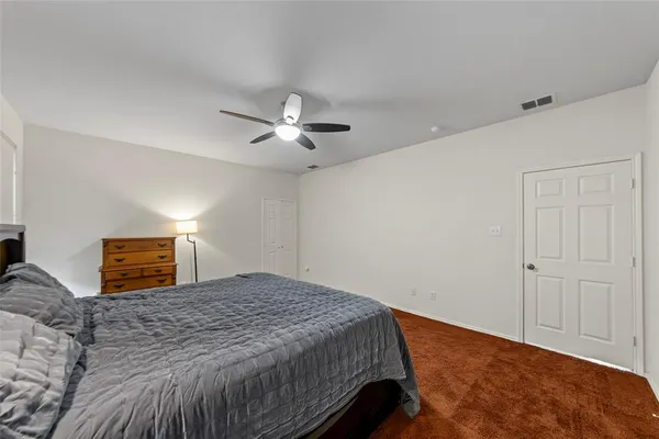 a bedroom with a large bed and a ceiling fan