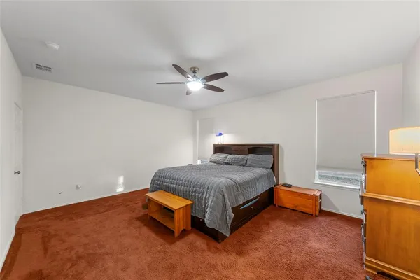 a bedroom with a bed and a ceiling fan