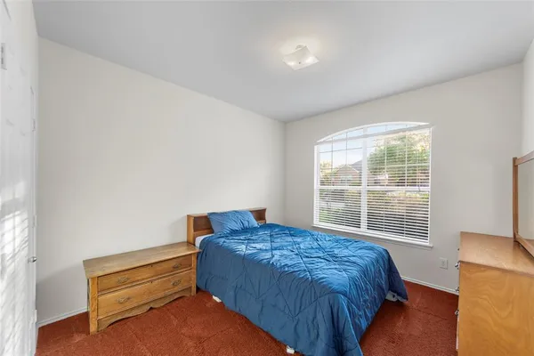 a bedroom with a bed and a window with outer view