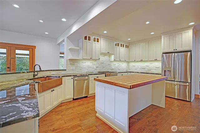 a kitchen with stainless steel appliances granite countertop a stove a refrigerator and a sink