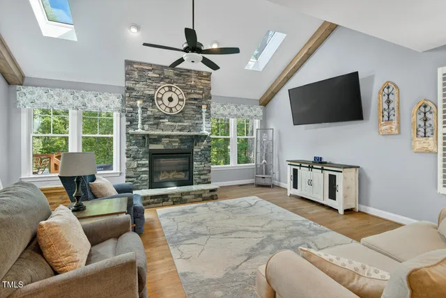 a living room with furniture a flat screen tv and a fireplace