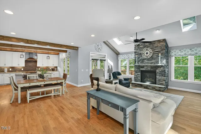 a living room with furniture a fireplace a flat screen tv and a large window