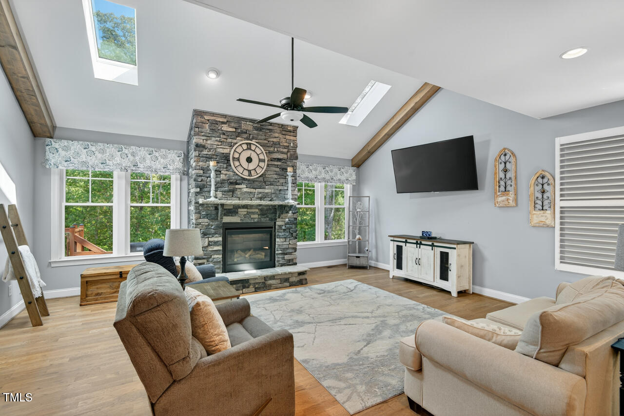 67 Ada Court Pittsboro, NC 27312 - Photo 14 of 63 a living room with furniture a fireplace a flat screen tv and a large window