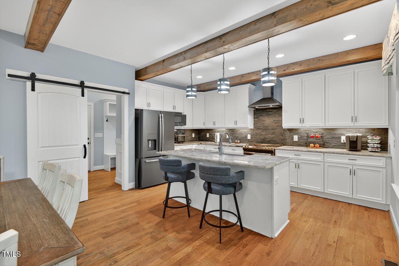 67 Ada Court Pittsboro, NC 27312 - Photo 20 of 63 a kitchen with stainless steel appliances granite countertop a refrigerator a stove a sink dishwasher and white cabinets with wooden floor