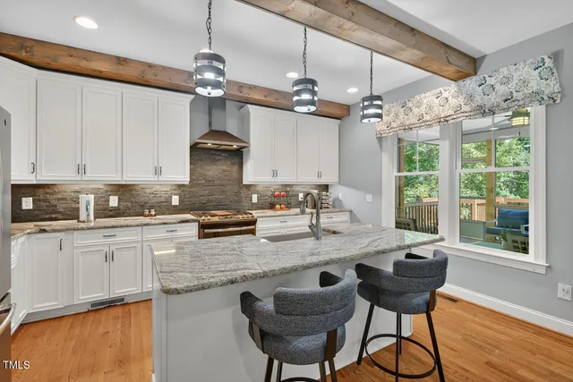 a kitchen with stainless steel appliances granite countertop a sink a stove and a refrigerator