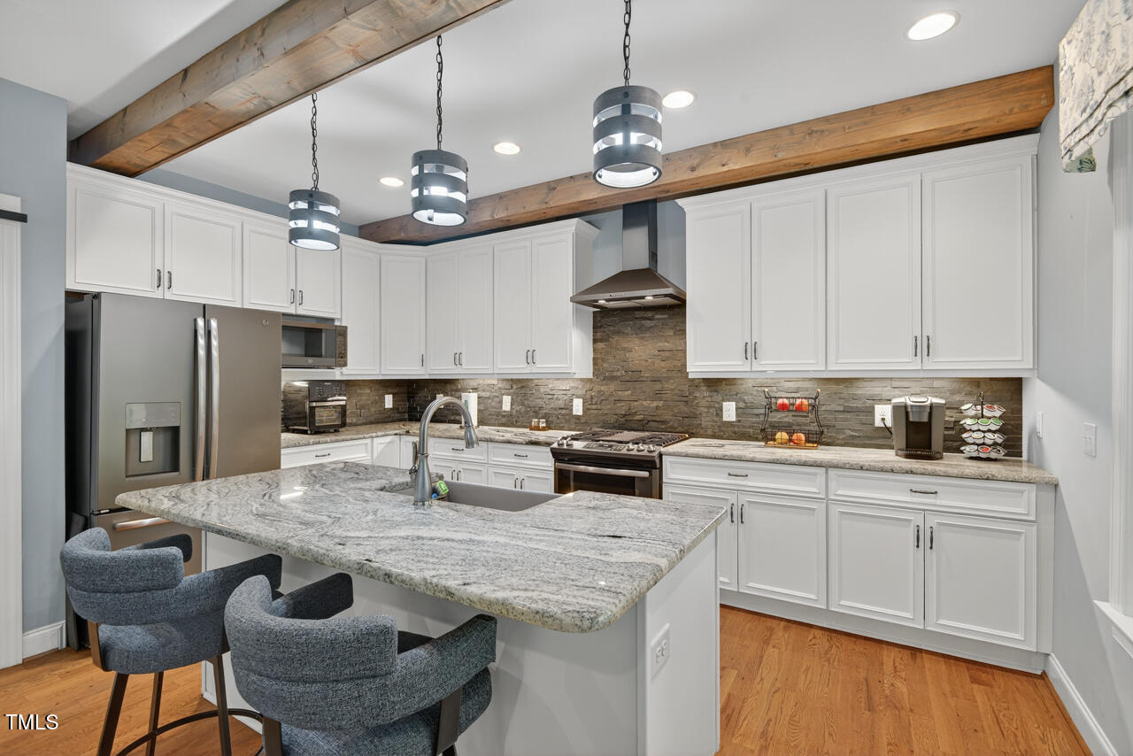 67 Ada Court Pittsboro, NC 27312 - Photo 23 of 63 a kitchen with stainless steel appliances granite countertop a sink a stove and a refrigerator
