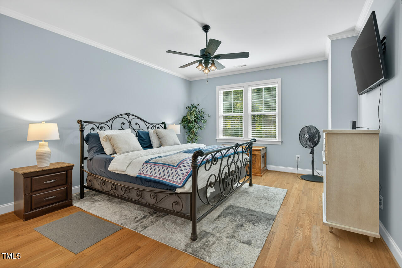 67 Ada Court Pittsboro, NC 27312 - Photo 32 of 63 a spacious bedroom with a bed a flat screen tv and a window