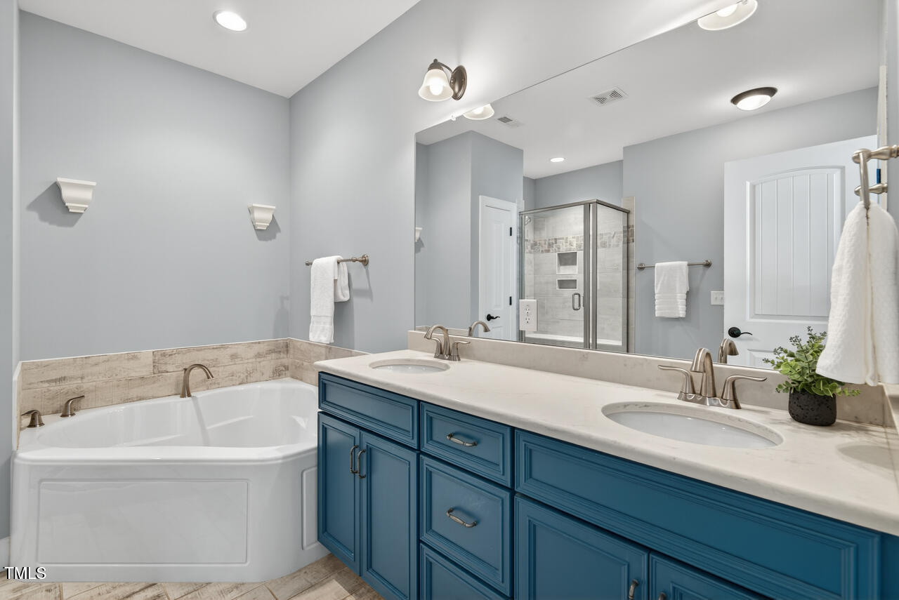 67 Ada Court Pittsboro, NC 27312 - Photo 40 of 63 a bathroom with a sink double vanity granite tub shower and a mirror