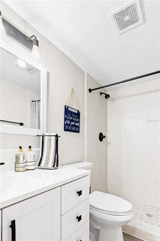 a bathroom with a shower a sink a toilet and a shower